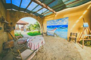 una habitación con una mesa y una pintura del océano en CASTLE KARPASIA Guest House en Rizokarpaso