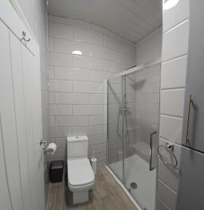 uma casa de banho branca com um WC e um chuveiro em Edgerton Studios em Huddersfield