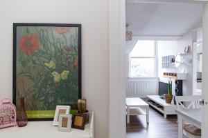 a living room with a painting of flowers on the wall at Plush Stay for Four in Central Brixton in London