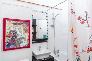 倫敦的住宿－Plush Stay for Four in Central Brixton，浴室在墙上画画,旁边是水槽