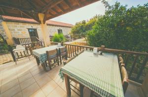 un patio con 2 mesas y sillas en una terraza en CASTLE KARPASIA Guest House, en Rizokarpaso