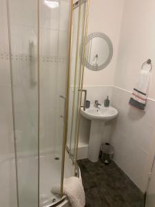 a bathroom with a shower and a sink at Argyll Apartment Loch Lomond in Balloch