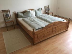 un letto con struttura in legno in una camera da letto di Gemütliche Ferienwohnung für 6 Personen im Schloss Kastorf a Knorrendorf