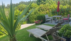 a patio with a table and chairs in a garden at Ferienwohnung "Am Halbenstein" in Hörbranz