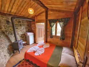ein Schlafzimmer mit einem Bett in einem Zimmer mit einem Herd in der Unterkunft Antik Vadi Bungalow in Edremit
