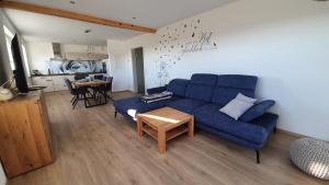 a living room with a blue couch and a table at Schnetter Hummel, Apartment 1 in Masserberg