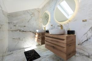 een badkamer met 2 wastafels en een spiegel bij 5 bedrooms house with private pool enclosed garden and wifi at Sibenik 5 km away from the beach in Šibenik