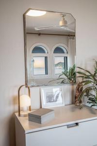 - un miroir au-dessus d'une commode dans une chambre dans l'établissement La Caseta de la Fosca, en el mar. By the sea., à Palamós