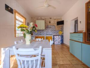 a kitchen with a table with chairs and a vase of flowers at Villa Assunta in Lecce