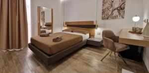 a bedroom with a bed and a desk and a chair at B&B Altomare in Lampedusa
