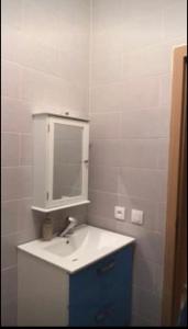ein weißes Badezimmer mit einem Waschbecken und einem Spiegel in der Unterkunft Appartement tanger Beach in Tangier