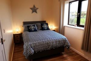 a bedroom with a bed and a star on the wall at Lovely two bed home in Cemaes, Anglesey in Cemaes Bay