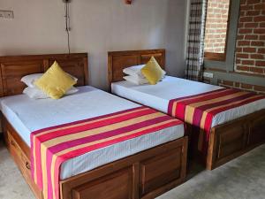 two beds sitting next to each other in a room at The Hideaway in Kurunegala