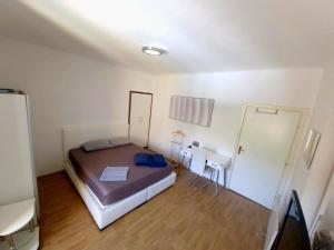 a small bedroom with a bed and a desk at Apartments Eis in Baška