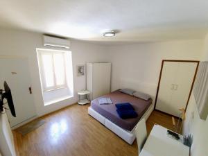 a small bedroom with a bed and a window at Apartments Eis in Baška