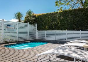 a swimming pool with a fence and a table and chairs at Oaklands On The Knoll by Dream Resorts in Knysna