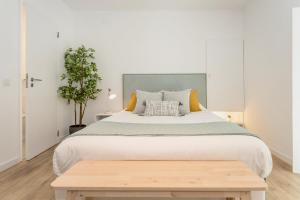 a bedroom with a large bed and a wooden table at Setúbal CityCenter Studios in Setúbal