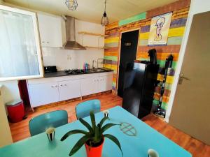 uma cozinha com uma mesa e um frigorífico em ConcarnOLoc em Concarneau