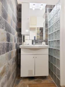 a bathroom with a white sink and a brick wall at SempreViva Sea Houses in Diakofti +129 photos