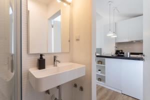 a white bathroom with a sink and a mirror at Setúbal CityCenter Studios in Setúbal +28 photos