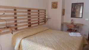 a bedroom with a bed and a wooden headboard at Casa Bella in Gela