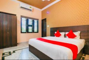 um quarto com uma cama grande e almofadas vermelhas em Hotel Silk Inn Luxury At No Cost em Lucknow