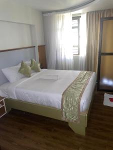 Schlafzimmer mit einem großen Bett und einem Fenster in der Unterkunft SILVER SLOPES RESORT AND SPA in Kagio