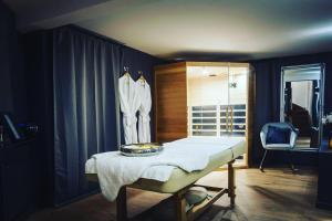 ein Ankleidezimmer mit einem Bett und einem Stuhl darin in der Unterkunft Hédoné Suite de luxe et Spa privatif in Nancy
