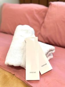 a pile of towels on a bed with a price tag at Casa Abigail Shore 3 in Manila