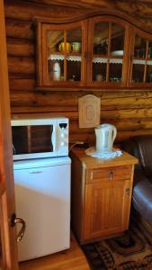 una cucina con frigorifero e forno a microonde su un tavolo di Gojaus smukle a Molėtai