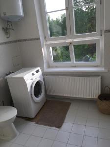 a washing machine in a bathroom with a window at Gemütliche Ferienwohnung für 3 Personen im Schloss Kastorf in Knorrendorf