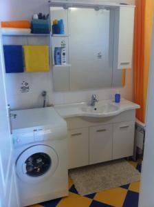 a bathroom with a washing machine and a sink at Holiday Home Panorama in Zubovići +24 photos