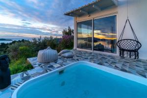 a swimming pool with a view of a house at Indigo Boutique Home in Skiathos Town