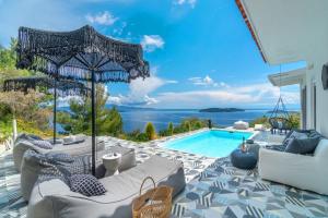 a villa with a swimming pool and a view of the ocean at Indigo Boutique Home in Skiathos Town