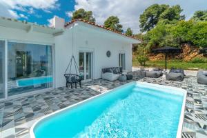 a villa with a swimming pool in front of a house at Indigo Boutique Home in Skiathos Town