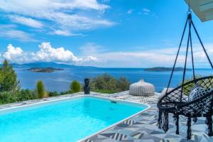 a patio with a swing and a swimming pool at Indigo Boutique Home in Skiathos Town