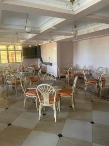 a dining room with tables and chairs in a room at SILVER SLOPES RESORT AND SPA in Kagio