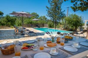 a table with food and drinks next to a pool at A Casa D' Irene Gaios Paxos in Gaios