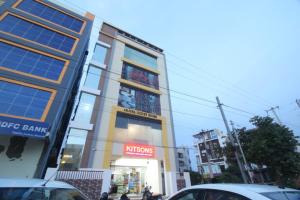 a building on a city street with people in front of it at Arjuna Luxury Rooms in Hyderabad