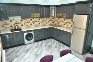 a kitchen with gray cabinets and a washer and dryer at Foothills Villa in Gabala