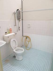 y baño con aseo y ducha. en EBH guesthouse, en Melaka