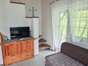 a living room with a tv on a wooden cabinet at Apartma Gea, Terme Olimia in Podčetrtek