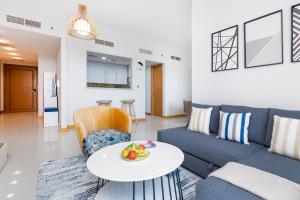 a living room with a blue couch and a table at Vacay Lettings -2 Bed Iris Blue Dubai Marina in Dubai