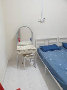 Zimmer mit einem Bett, einem Stuhl und einem Spiegel in der Unterkunft EBH guesthouse in Malakka