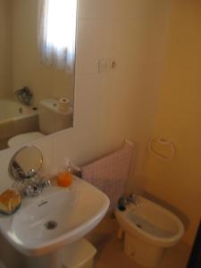 a bathroom with a sink and a toilet and a mirror at Casa Enriu-Alojamiento y desayuno in Vilaller