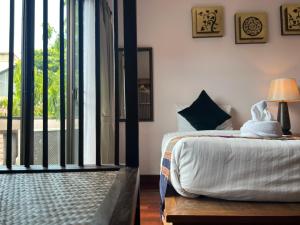 Schlafzimmer mit einem Bett und einer Glasschiebetür in der Unterkunft Pha Thai House in Chiang Mai