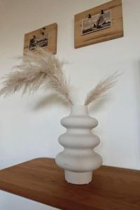 a white vase sitting on a table with feathers in it at Gerrit's Guesthouse Grou in Grou