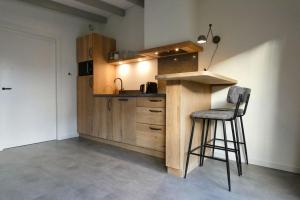 a kitchen with a counter and a bar with a stool at Gerrit's Guesthouse Grou in Grou