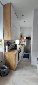 a kitchen with white cabinets and a wooden counter top at Apartament w Centrum in Nysa