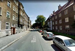 an empty street with parked cars and buildings at Apartament w Centrum in Nysa +3 photos